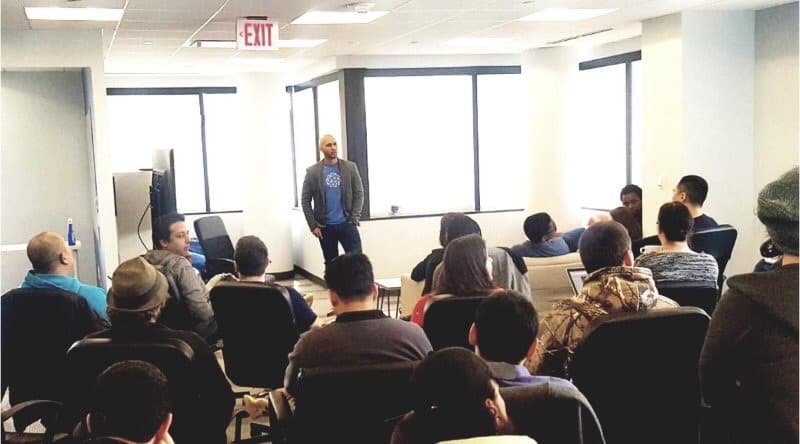 Anthony Day speaking to a room of builders at a meetup